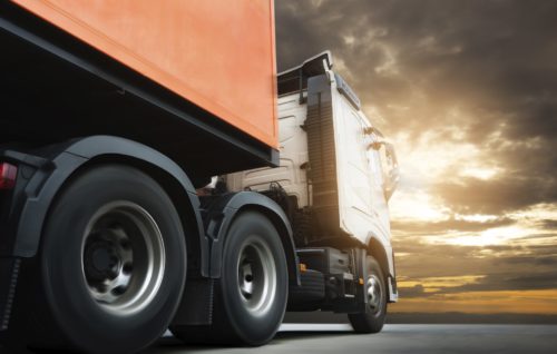 Semi truck trailer driving on road at sunset sky. Cargo freight truck, Logistics and transportation.