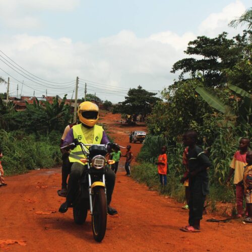 A MAX-certified EV driver takes a customer from the Gbamu Gbamu community center to the highway junction.