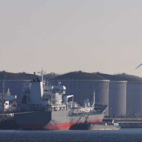 large ship in harbor with windmills in background