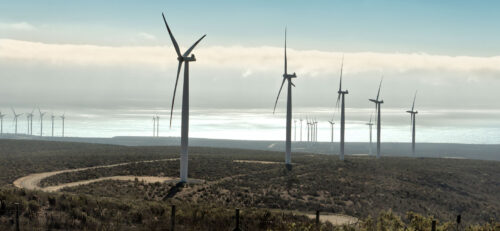 wind turbines on hill overlooking water